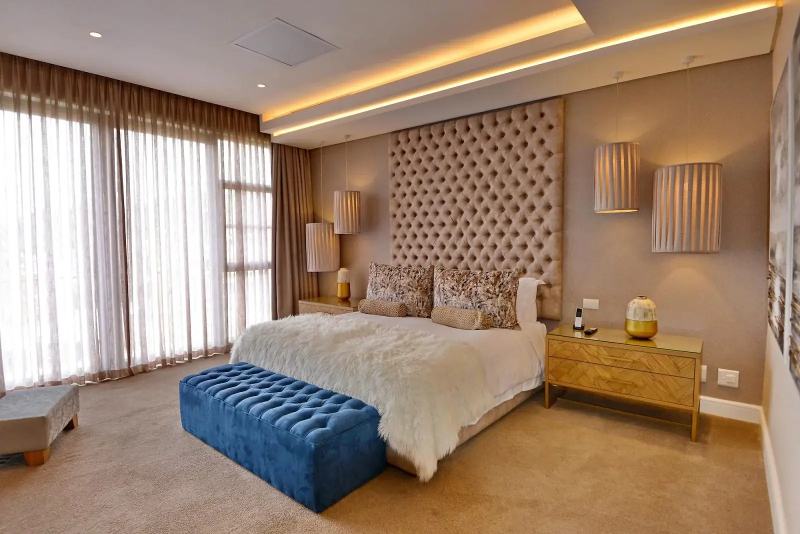 Spacious penthouse in Johannesburg, large bed and a blue ottoman